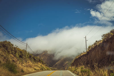 Country road against sky