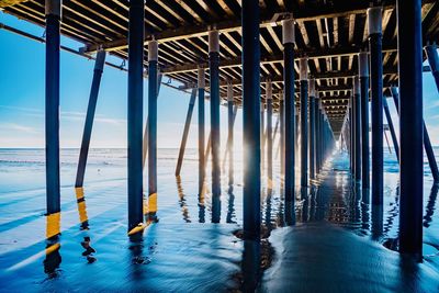 Pier over sea against blue sky