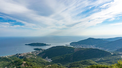 Scenic view of mountains by sea against cloudy sky