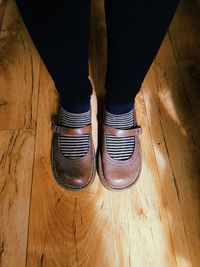 Low section of woman standing on hardwood floor