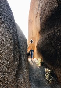 Rear view of man walking on rock