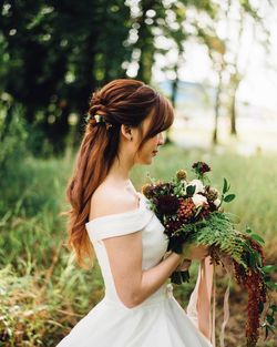 Young woman standing by flowering plants