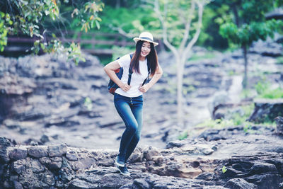 Full length portrait of young woman standing on land