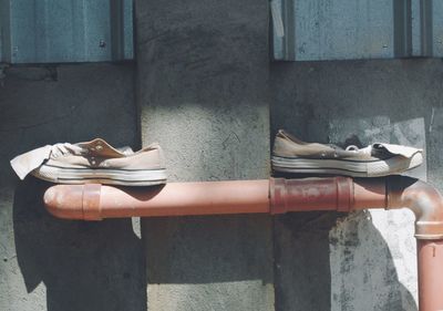 View of shoes on pipe against wall