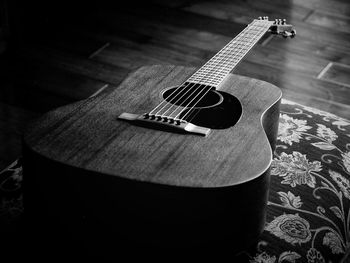 High angle view of acoustic guitar on pillow at home