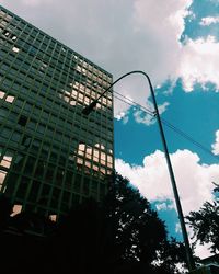 Low angle view of modern building against cloudy sky