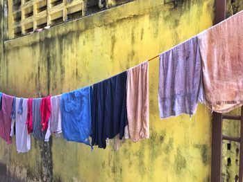 Laundry drying on clothesline against wall