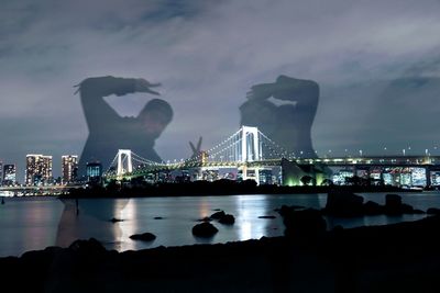 View of suspension bridge in city at night