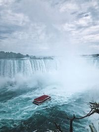 Scenic view of waterfall against sky