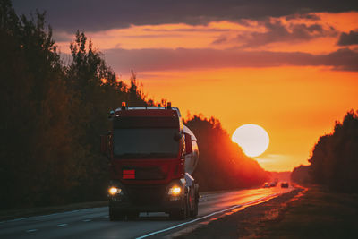 Cars on road at sunset