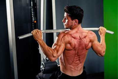 Shirtless man exercising in gym