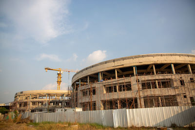 Low angle view of abandoned construction site against sky