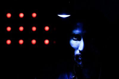 Portrait of man with illuminated lights in darkroom