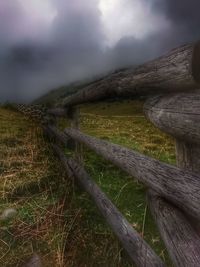 Wooden fence on field against sky