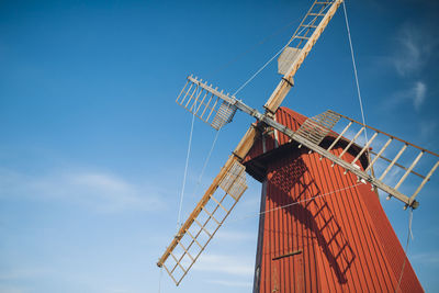 Low angle view of windmill against blue sky