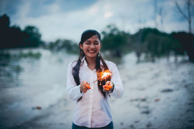 Portrait of a smiling young woman standing in water