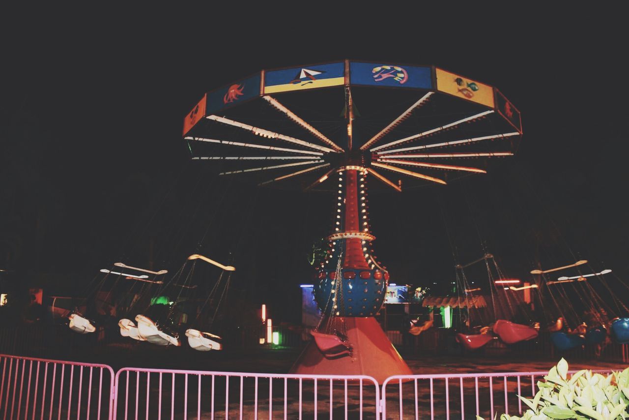 illuminated, night, low angle view, built structure, architecture, clear sky, arts culture and entertainment, text, lighting equipment, amusement park, communication, multi colored, building exterior, decoration, amusement park ride, sky, outdoors, no people, culture, ferris wheel