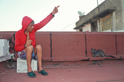 Full length of boy sitting on wall