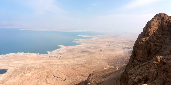 Scenic view of sea and mountains against sky