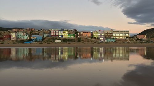 Buildings by sea against sky