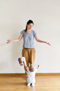 Full length of mother and baby girl on floor at home