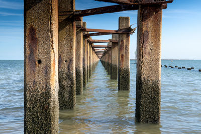 Wooden pier on sea against sky