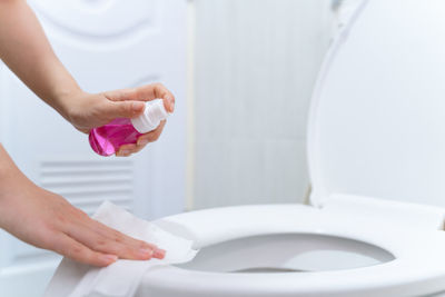 Midsection of woman holding hands in bathroom