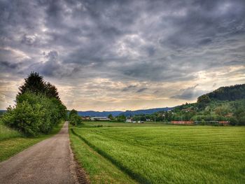 Road amidst field against sky