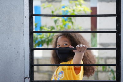 Portrait of girl looking through window