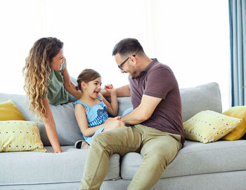 Father and daughter sitting on sofa