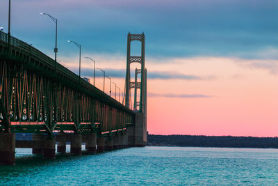 Pier over sea against sky during sunset