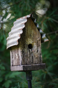 Close-up of birdhouse on wooden post in field