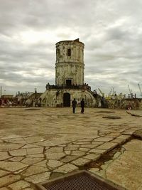 Tourists against cloudy sky