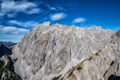 Low angle view of snowcapped mountains against blue sky