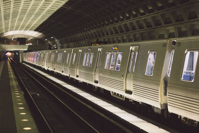 Train at illuminated railroad station at night