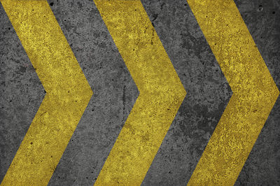 High angle view of yellow arrow symbol on road