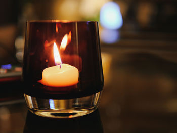 Close-up of illuminated tea light candle on table