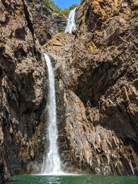 Low angle view of waterfall on rocks