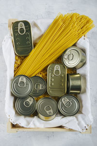 Top view of various cans of non-perishable food and spaghetti