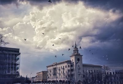 Low angle view of buildings against cloudy sky