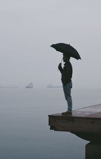 Man standing in sea against clear sky