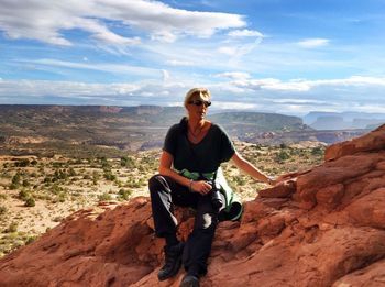 Woman sitting on rock formation at arches national park