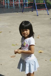 Portrait of girl playing on sand at beach