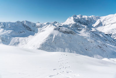 Group of people skiing in fresh powder snow in vast alpine landscape, gastein, austria.