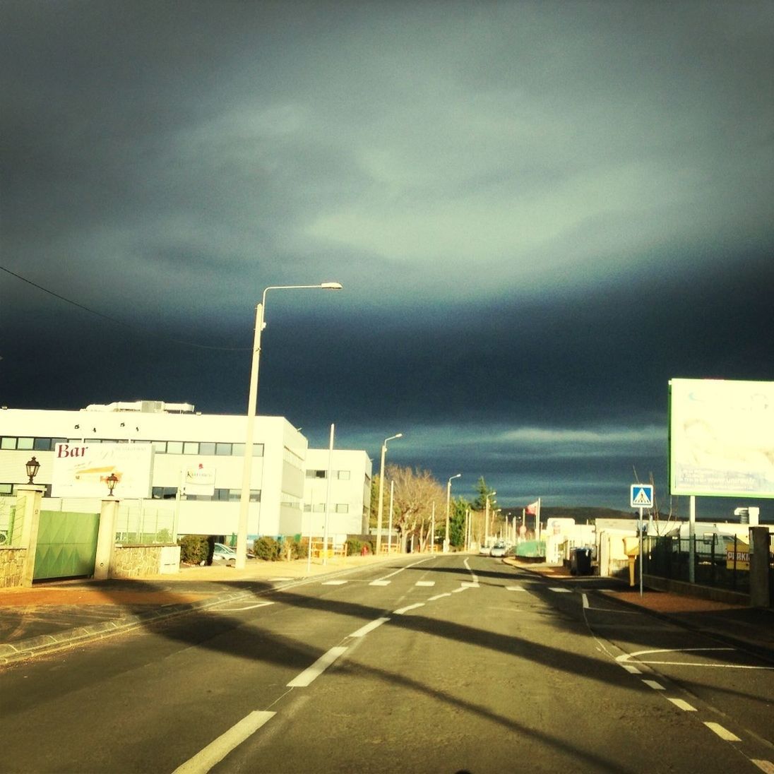 road, transportation, sky, the way forward, building exterior, cloud - sky, road marking, street, architecture, cloudy, built structure, car, diminishing perspective, cloud, mode of transport, overcast, land vehicle, vanishing point, empty, outdoors