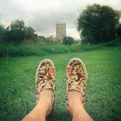 Low section of person relaxing on grassy field