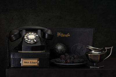 Close-up of telephone booth on table against black background