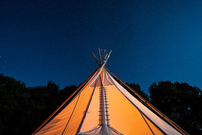 Low angle view of tent against clear sky at night