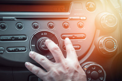 Cropped hand of man playing music in car