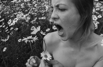 Shirtless woman by white flowering plants